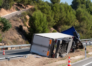 Large semi-truck overturned on its side after a highway accident.