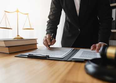 Lawyer reviews a legal document next to the scales of justice. Ensure Effective Management Of Legal Challenges.