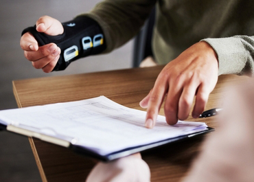 Injured person showing a medical monitoring device to a lawyer, Optimizing Compensation Following An Injury.