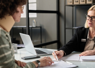 Person with a neck brace consulting with an attorney. Title: The Importance Of Communication Between You And Your Injury Law Firm.