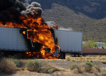 Close-up of a semi-truck engulfed in flames after a fiery crash. Title: Three Killed In Fiery Crash On New Jersey Highway.
