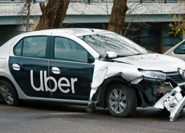 Damaged Uber car after an accident. title: Your Options When Your Uber Driver Is At Fault.