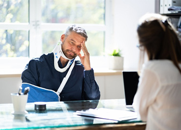 Man with a broken arm in a sling and a neck brace looking distressed Title: Auto Accident Lawyer Injury Claims
