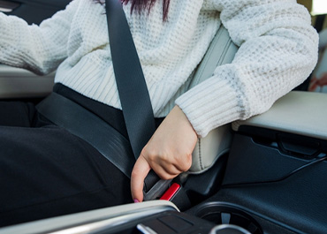 Person fastening a seat belt in a car. Title: How Important Are Seat Belts?