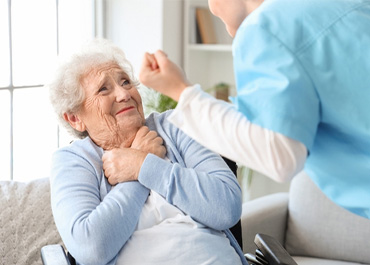 Elderly woman holding her chest, looking worried, with a caregiver. Title: When To Contact A Bedsore Lawyer For Elderly Care Abuse.