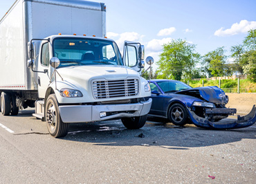 Semi-truck accident scene with a damaged car. Title: How Semi-Truck Accidents Differ From Car Accidents In Legal Claims.