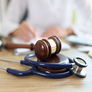 East Brunswick NJ Law Firm – Close-up of judge’s gavel and doctor’s stethoscope on office desk
