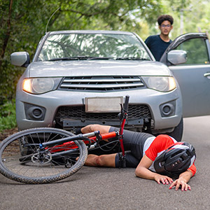 Bicycle accident lawyer New Brunswick – mountain bike crash with car, young rider receiving medical help