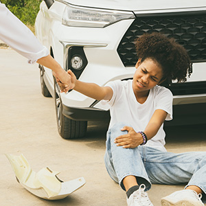 Pedestrian accident scene with man helping another stand – Edward Blinder, New Brunswick pedestrian accident lawyer
